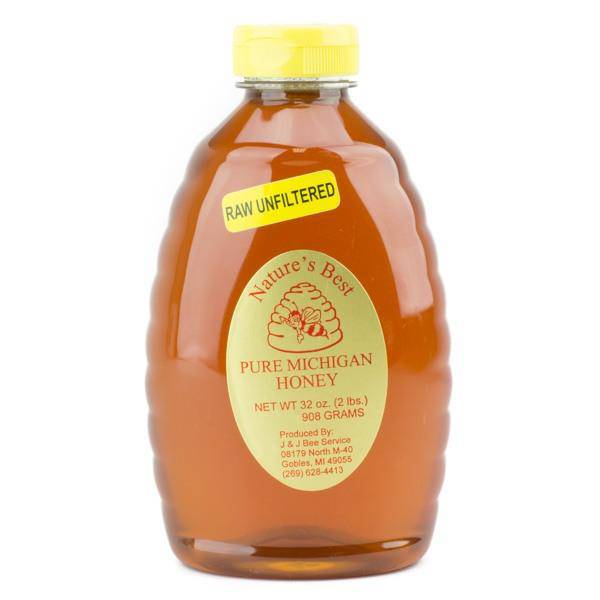 Jar of raw honey, unheated and unfiltered, shown next to a honey dipper